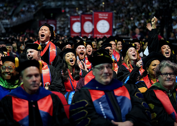 Graduates screaming excitedly in crowd